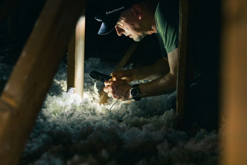 Insulation Budget - man in green crew neck t-shirt holding smoking pipe