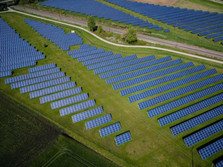 Renewable Energy - aerial photography of grass field with blue solar panels