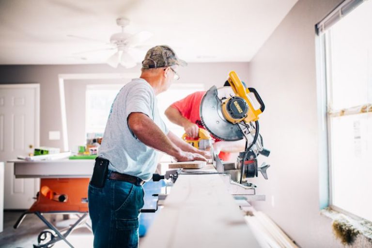 DIY Plumbing - man standing infront of miter saw