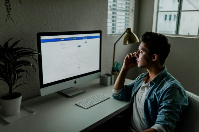 Mortgage Application - man in blue denim jacket facing turned on monitor