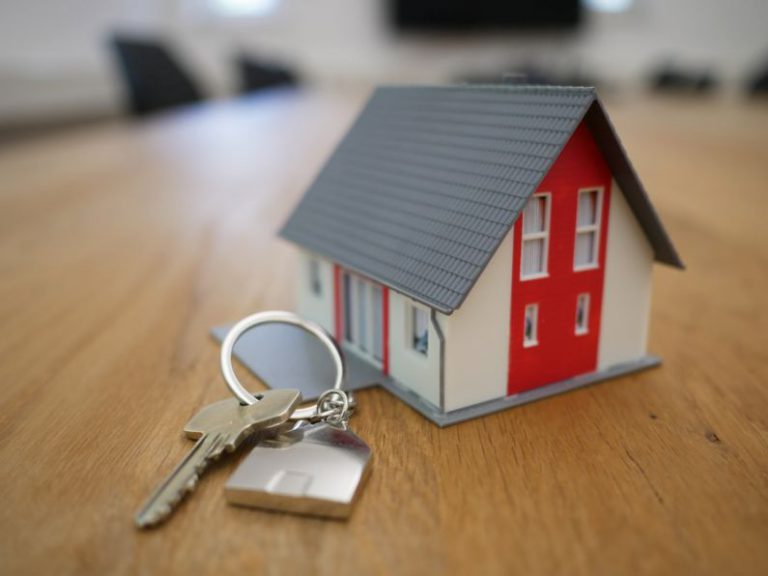 Property Tax - white and red wooden house miniature on brown table