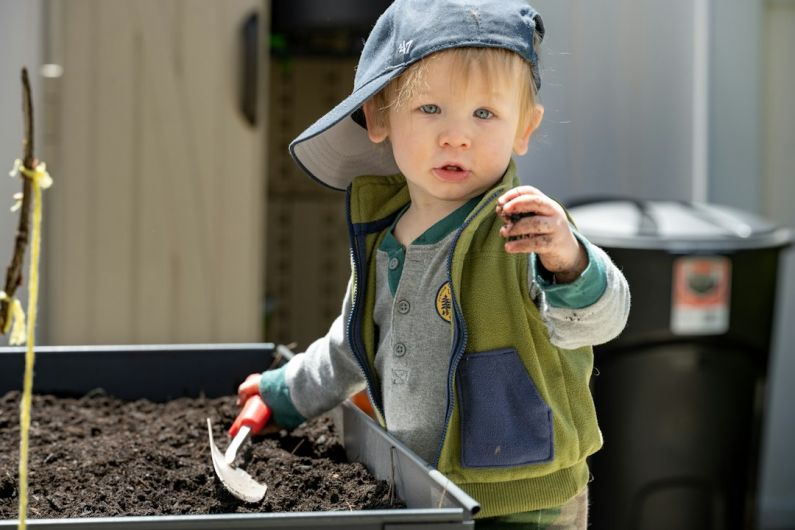 Raised Garden Bed - a baby holding a toothbrush