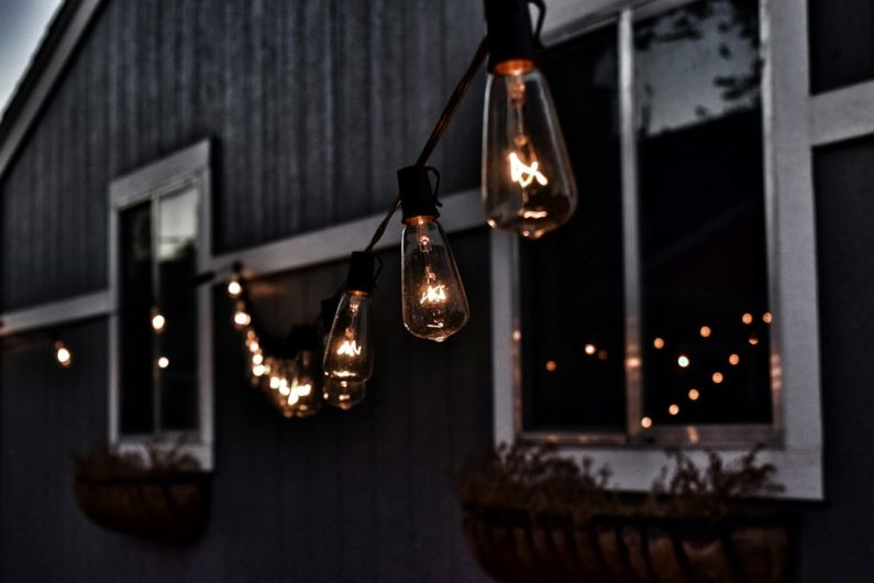 Outdoor Lighting - piled hanging lighted bulb beside house