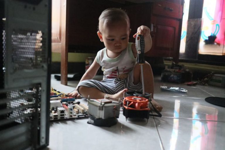 Durable Flooring - a little boy sitting on the floor playing with a toy