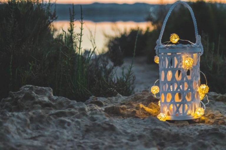 Outdoor Decor - yellow candle lantern on brown sand