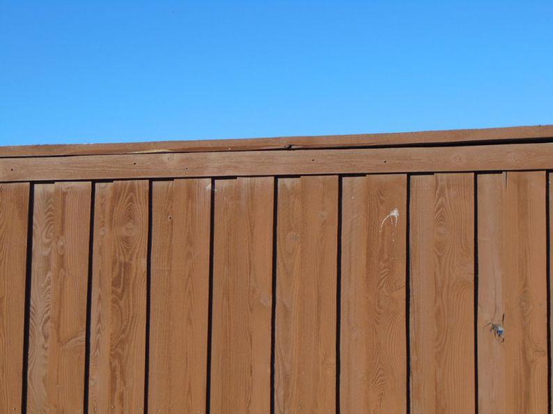 Yard Fencing - a wooden fence with a blue sky in the background