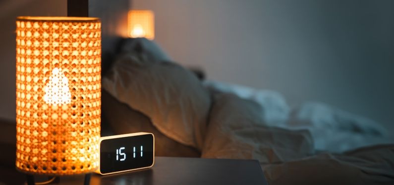 Smart Sensors - a clock sitting on top of a table next to a lamp