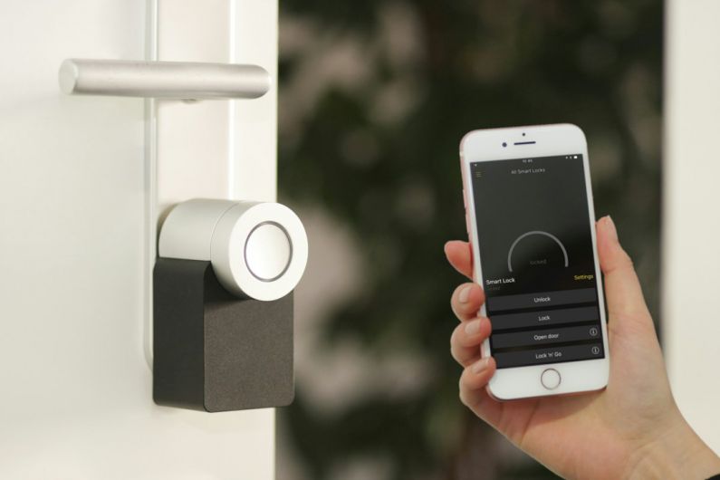 Smart Home Security - gold Apple iPhone smartphone held at the door